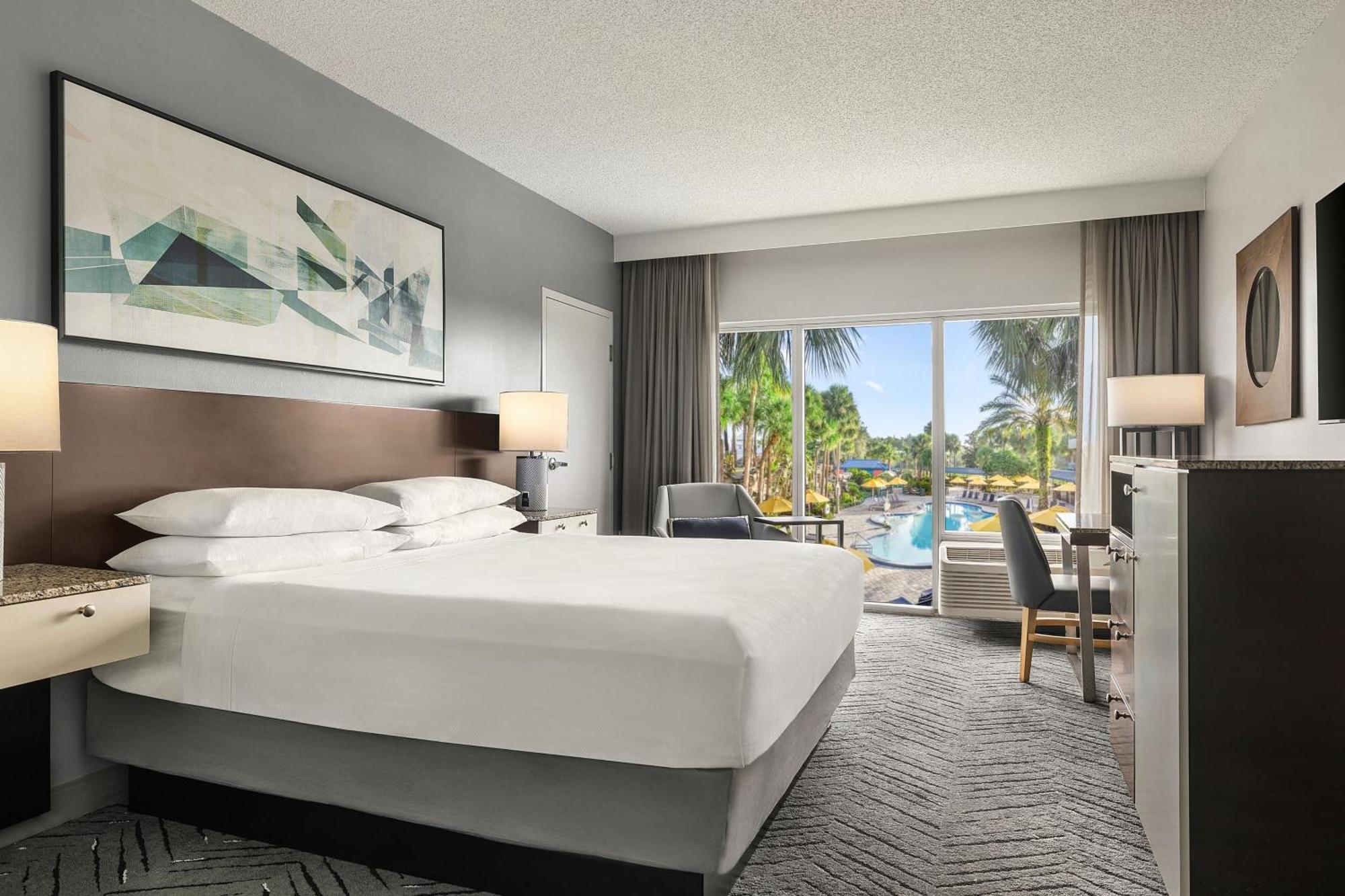 Quarto com cama king-size e vista da piscina.